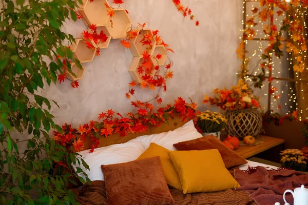 Autumn bedroom, living room interior. Red and yellow leaves and flowers in the vase and pumpkin on light background