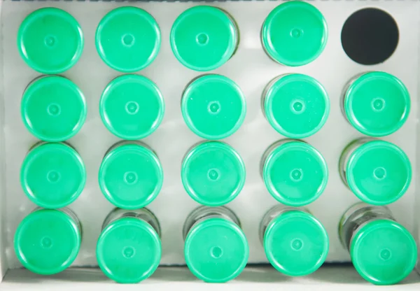 Bovenaanzicht van injectie flesjes op papierlade sloot — Stockfoto