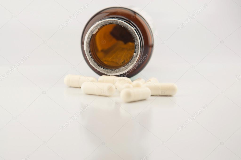 White capsule and brown bottle background