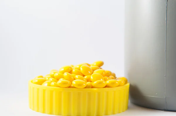 Coated yellow tablet on white — Stock Photo, Image