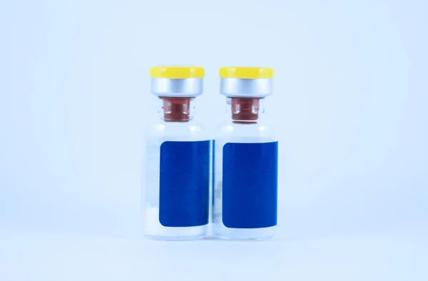 Yellow cap ampule and blue label — Stock Photo, Image