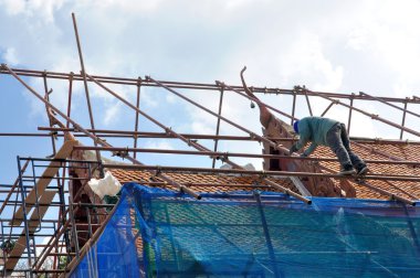 bir inşaat işçisi yüksek bir çatı üzerinde