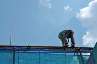 İnşaat işçisi yüksek bir çatı üzerinde risk kavramı göstermek