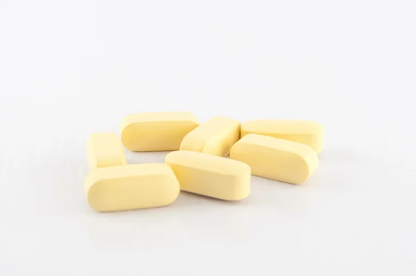 Yellow tablet on white background — Stock Photo, Image