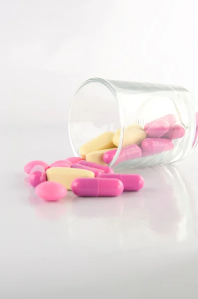 Médicament comprimé et capsule en verre sur fond blanc — Photo