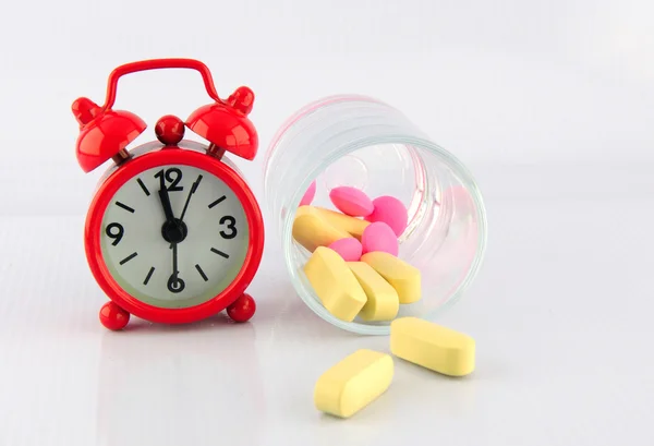 Red clock and tablet in glass on white background — Stock Photo, Image