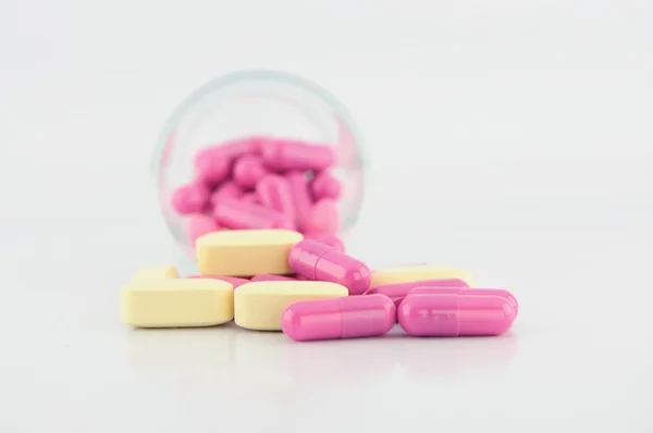 Лекарственные таблетки и капсулы в стекле — стоковое фото