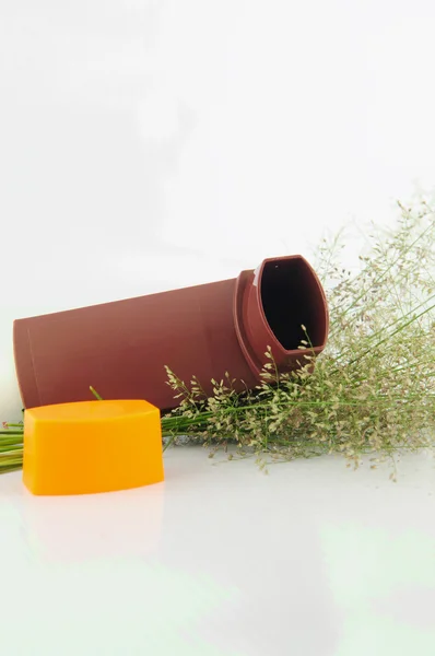 Inhalateur d'asthme brun et fleur d'herbe sur fond blanc — Photo