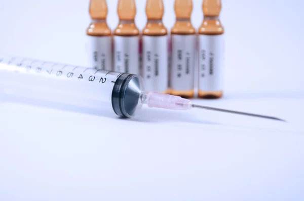 Disposable syringe and brown ampule — Stock Photo, Image