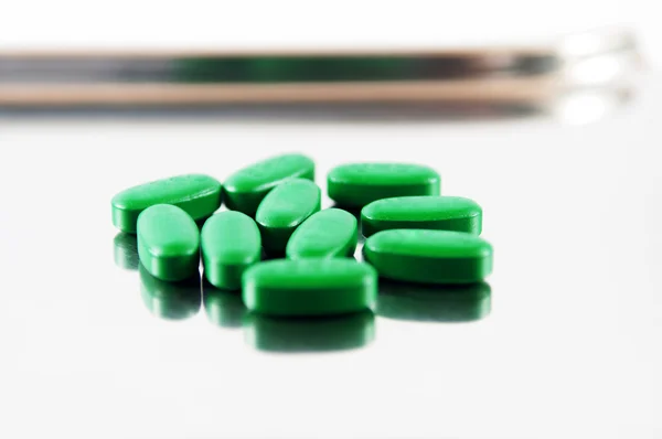 Зеленая таблетка на металлическом подносе — стоковое фото