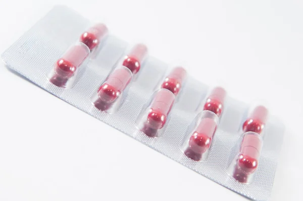 Red capsule in transparent blister pack — Stock Photo, Image