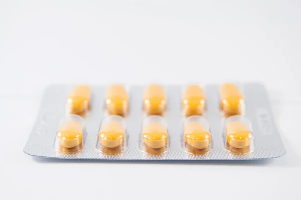 Yellow tablet in blister pack on white background — Stock Photo, Image