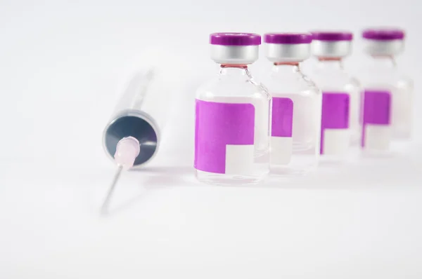 Arrange purple vial and disposable syringe on white background — Stock Photo, Image