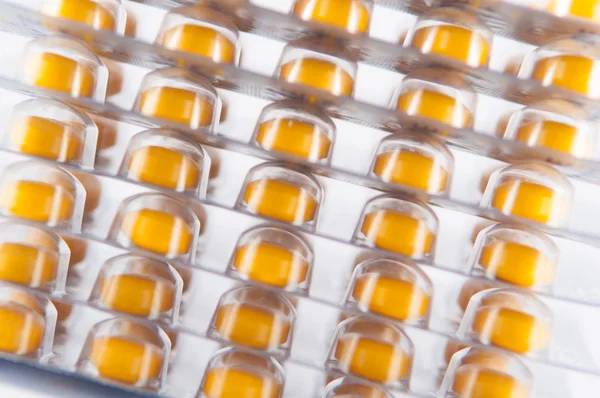 Layer of yellow tablet in blister pack on white show medicine co — Stock Photo, Image