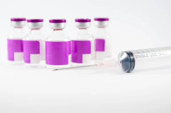 Purple vial and disposable syringe on white background — Stock Photo, Image