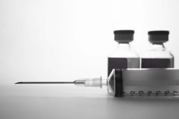 Disposable syringe and injection ampule background — Stock Photo, Image