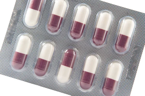 White and brown hard capsule in transparent blister pack — Stockfoto