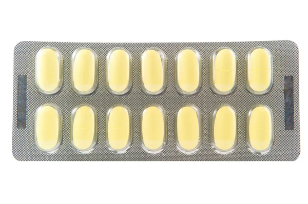 Closed up long yellow tablet in transparent blister pack — Stock Photo, Image