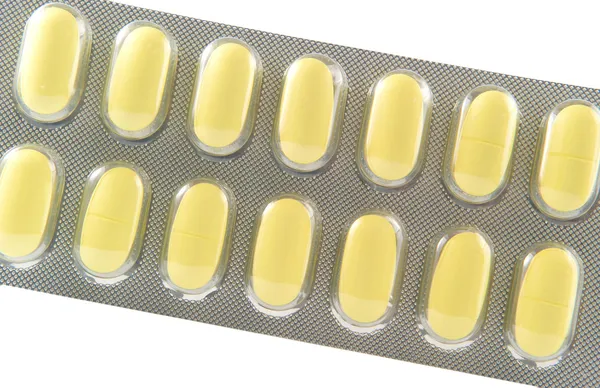 Stängt upp lång gul tablett i transparent blisterförpackning — Stockfoto