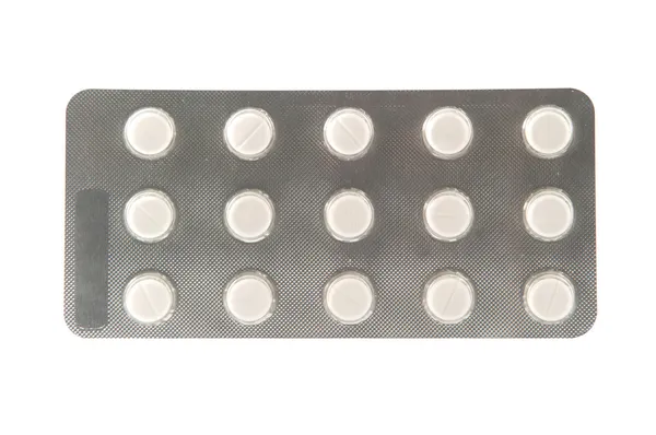 Obyčejný tablet v blistru na bílém pozadí — Stock fotografie