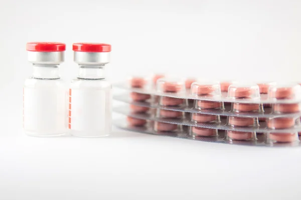 Kırmızı bere enjeksiyon flakon ve ilaç tablet blister — Stok fotoğraf