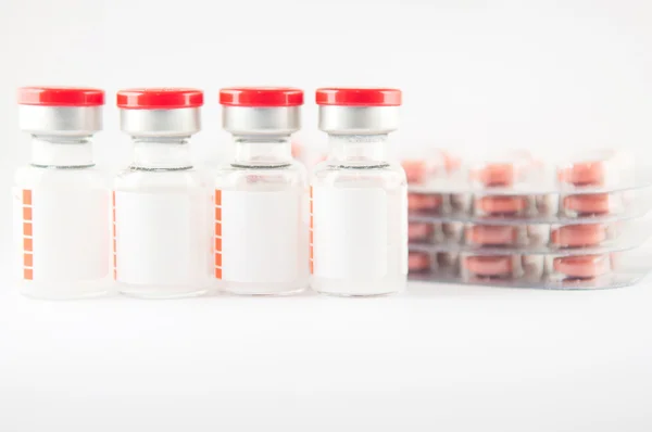 Vial inyectable de etiqueta blanca y comprimido del medicamento en blíster backgr —  Fotos de Stock