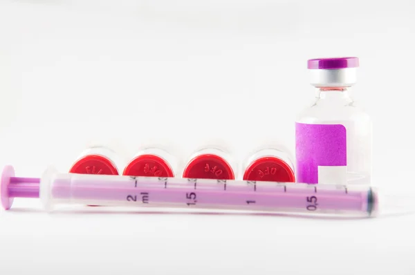 Purple disposable syringe on injection vials — Stock Photo, Image
