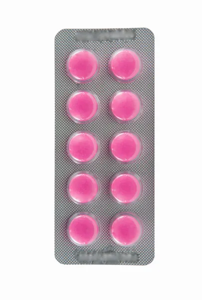 Růžové tablety v balení na bílém pozadí — Stock fotografie