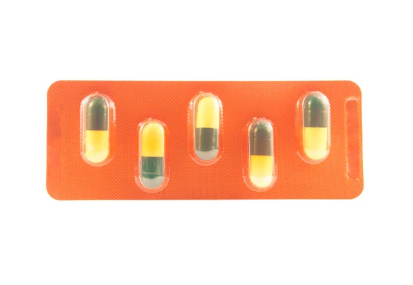 Yellow and green capsule in brown blister pack — Stock Photo, Image