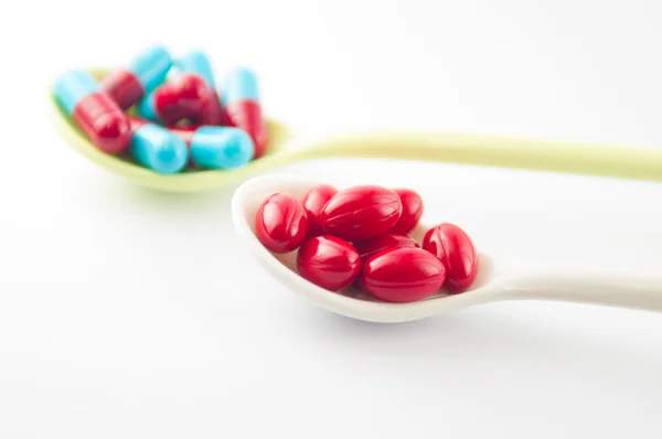 Spoon with tablet and capsule — Stock Photo, Image