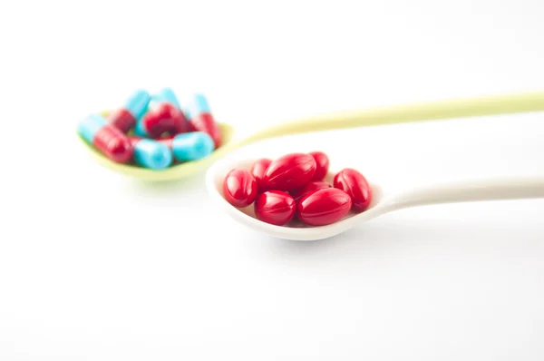 Spoon with tablet and capsule — Stock Photo, Image