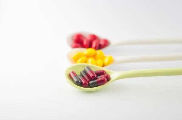 Spoon with tablet and capsule — Stock Photo, Image