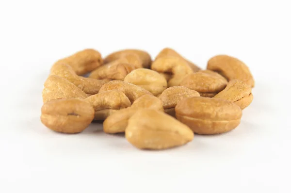 Pečené kešu ořechy na bílém pozadí — Stock fotografie
