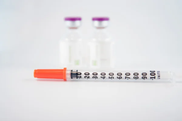 Dispoable syringe and Purple cap of medicine injection vial — Stock Photo, Image