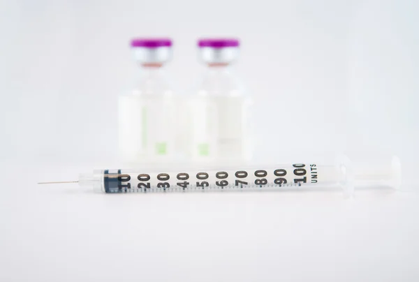 Диспобируемый шприц и фиолетовая крышка пузырька для инъекций лекарств — стоковое фото