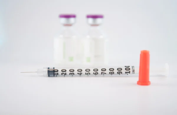 Dispoable syringe and Purple cap of medicine injection vial — Stock Photo, Image