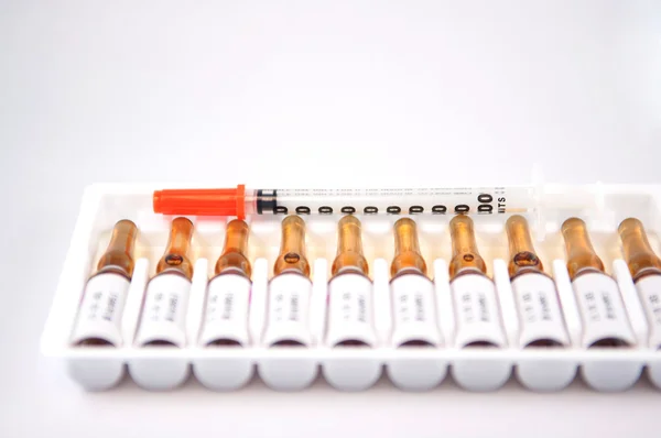 Disposable syringe on injection ampule pack — Stock Photo, Image