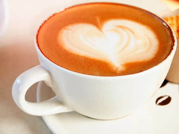 Tasse de café avec motif coeur dans une tasse blanche — Photo