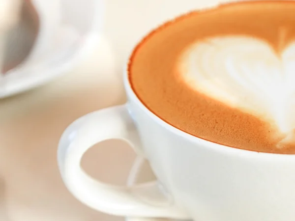 Tasse de café avec motif coeur dans une tasse blanche — Photo