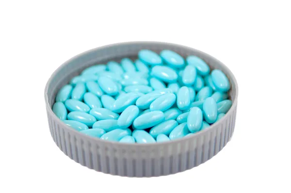 Comprimido de recubrimiento azul cerrado en la tapa del frasco de medicamento — Foto de Stock