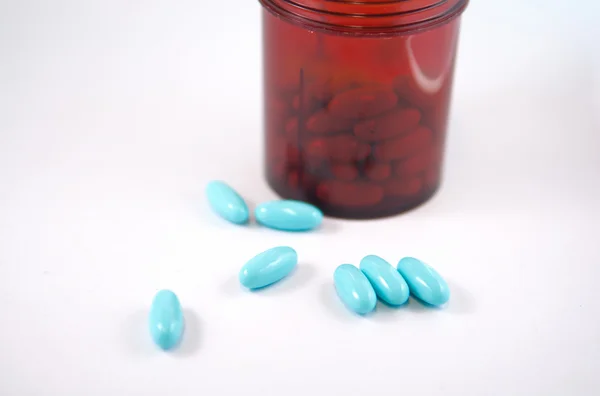 Closed up blue tablet from brown dispensing bottle — Stock Photo, Image