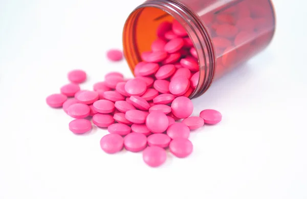 Pink tablet fall from dispensing bottle — Stock Photo, Image