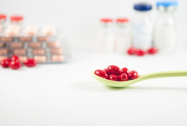 Comprimat roşu în lingură pe fundal medicamentos — Fotografie, imagine de stoc