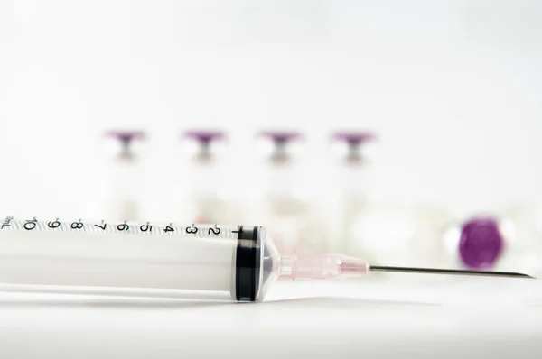 Frascos para injectáveis de tampa roxa e seringa mostram conceito de medicamento — Fotografia de Stock