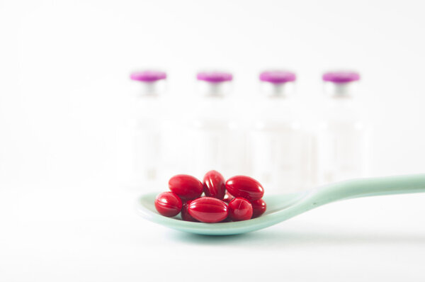 Таблетка с желтым покрытием в ложке
