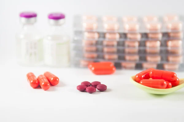 Orange capsule in spoon on blister pack background — Stock Photo, Image