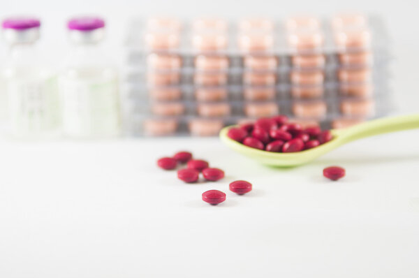 Таблетки в ложке на фоне медицины
