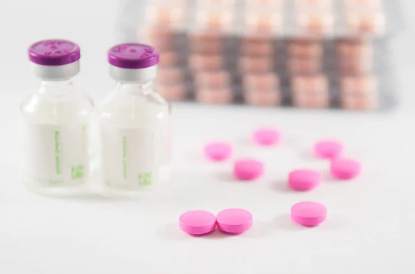 Розовые таблетки на фоне медицины — стоковое фото