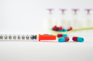 Kırmızı ve gri kapsül ve şırınga tıp kavramı göstermek