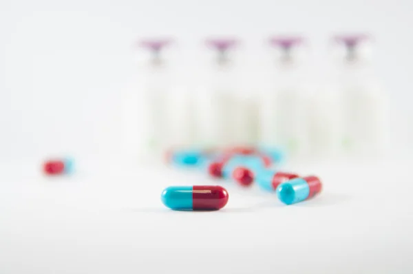 Red and Blue capsule on medicine background — Stock Photo, Image